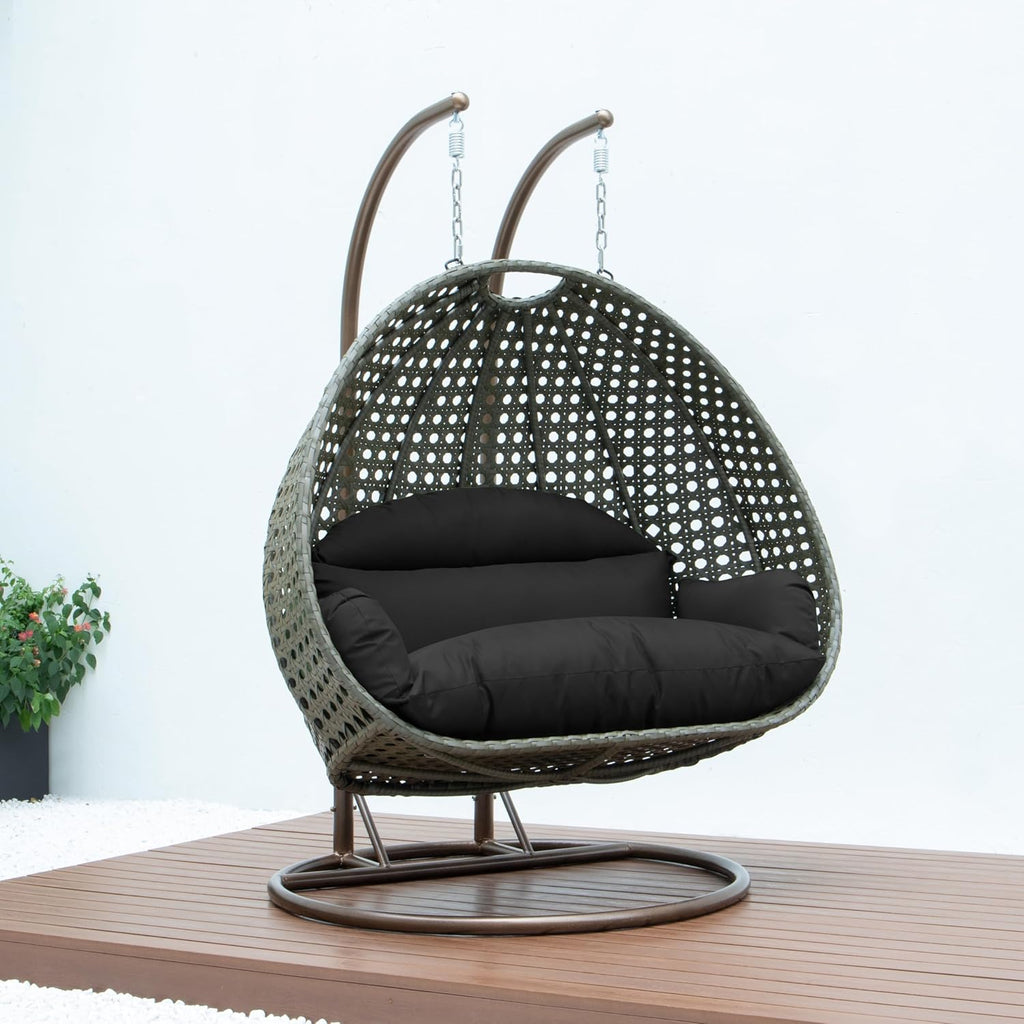 LeisureMod Black Wicker 2 Person Egg Swing Chair with Beige Stand and Cushions – Double Hanging Hammock Lounge for Patio, Indoor & Outdoor Use