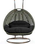 LeisureMod Black Wicker 2 Person Egg Swing Chair with Beige Stand and Cushions – Double Hanging Hammock Lounge for Patio, Indoor & Outdoor Use